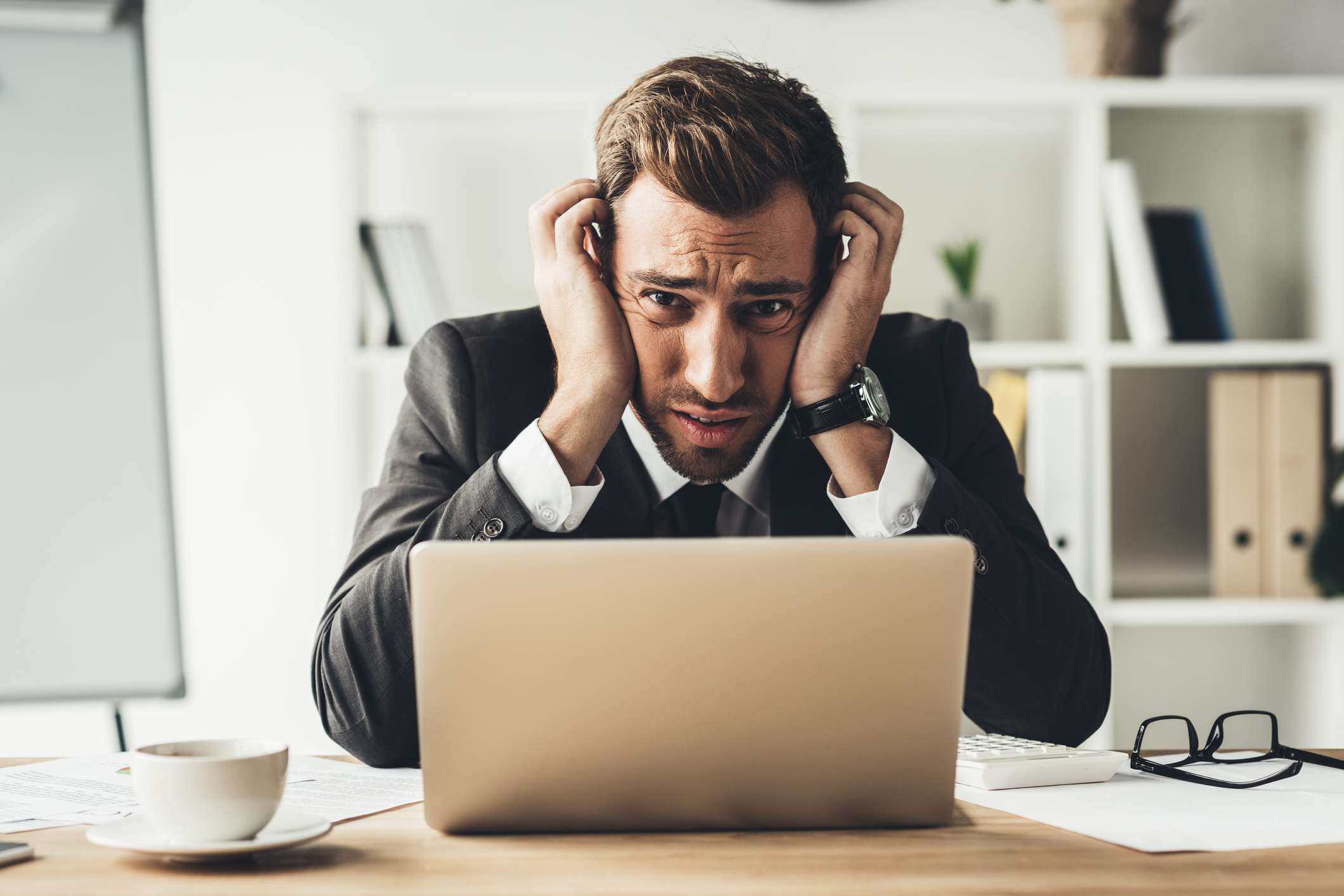 Embarrassed businessman with laptop