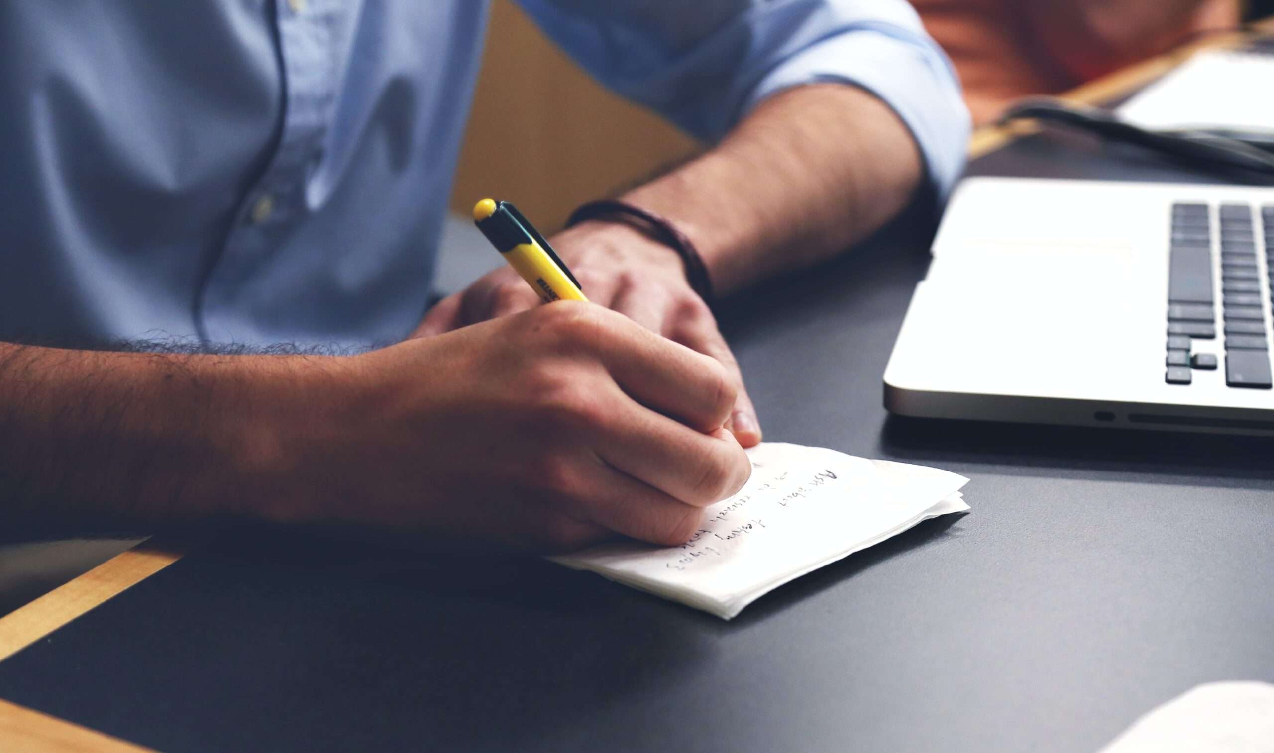 Person Writing on Paper Using Yellow and Black Pen Stock Photo