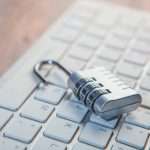 A combination lock rests on a computer keyboard.